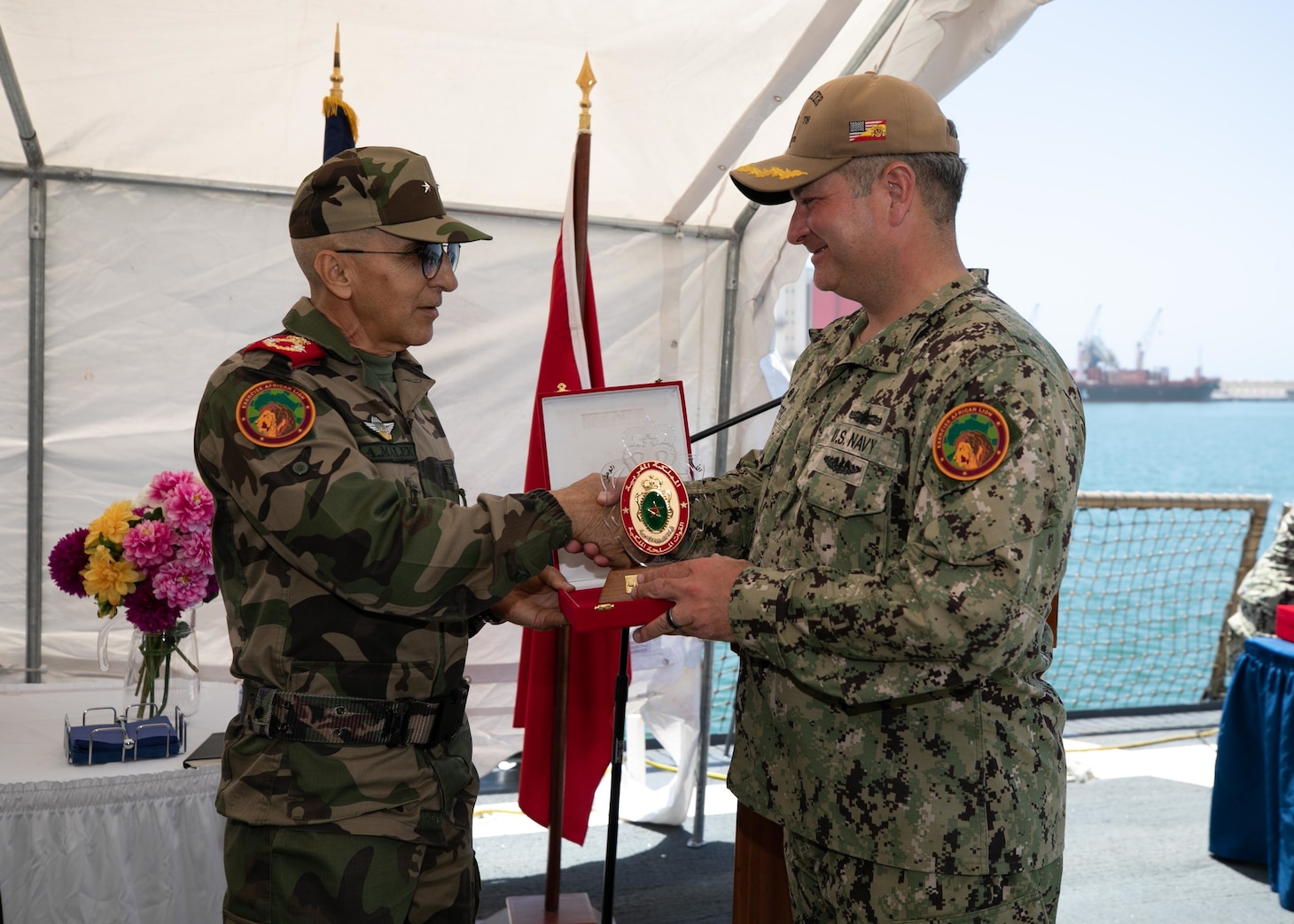 Brigadier General Abdellatif Malek J2 presents Rear Adm. Jeffery Spivey, vice commander of U.S. Sixth Fleet, with a gift during a reception aboard the Arleigh Burke-class guided-missile destroyer USS Porter (DDG 78) during exercise African Lion 22, June 28, 2022.