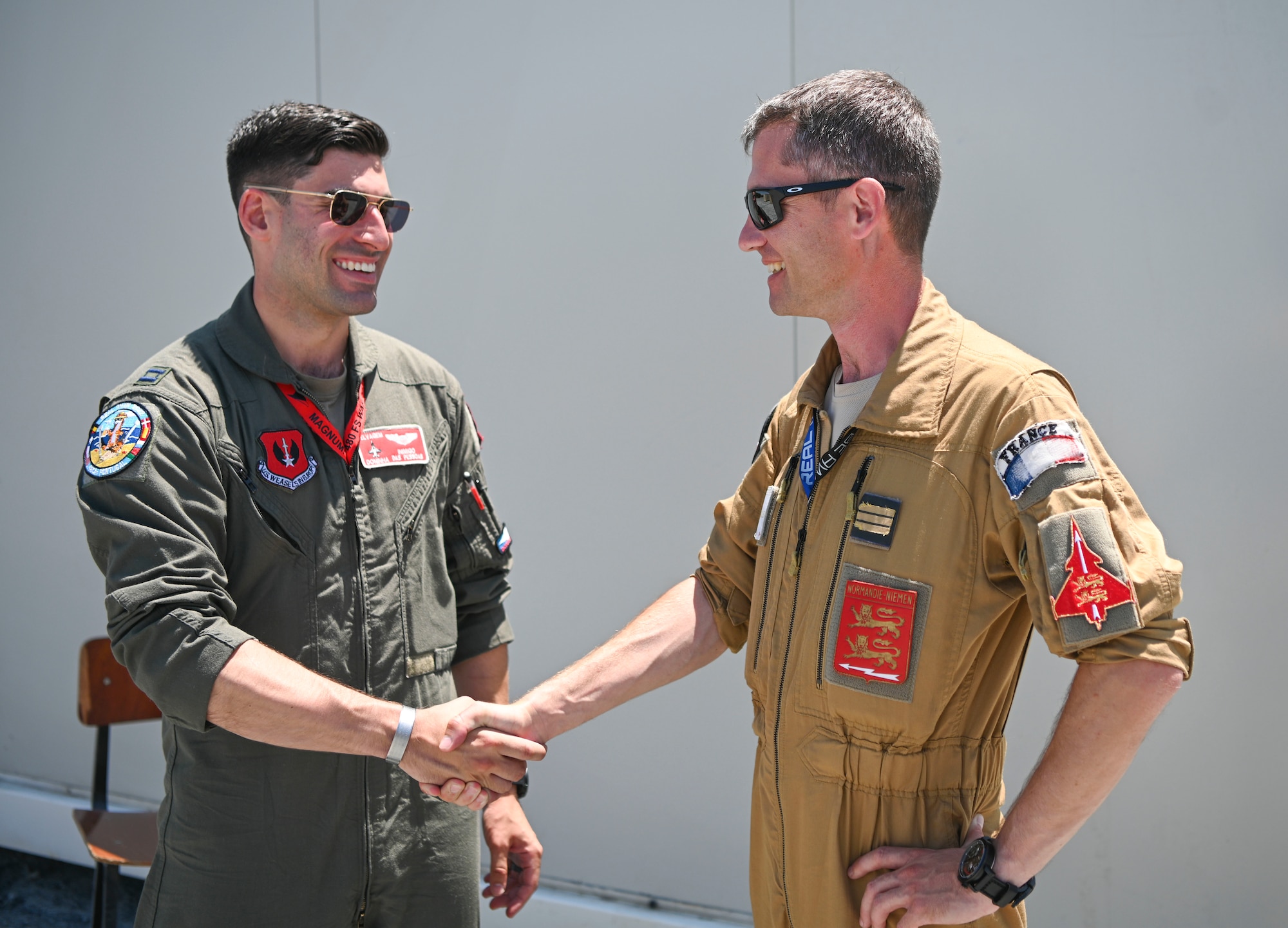 U.S. Air Force Capt. Domenick Stumpi, 480th Fighter Squadron pilot (left), stationed at Spangdahlem Air Base, Germany, shakes hands with Capt. Bibi, a French air force pilot assigned to the 2/30 Normandie Niemen Squadron at Exercise Real Thaw 22 on Beja Air Base, Portugal, July 6, 2022. Real Thaw is a Portuguese air force-led, multilateral training exercise aimed to strengthen the interoperability and skills of NATO Allies and Partners.  (U.S. Air Force photo by Tech. Sgt. Warren D. Spearman Jr.)