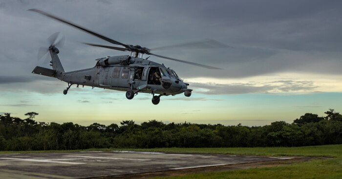 A U.S. Navy Sikorsky SH-60 Seahawk Helicopter with Helicopter Sea Combat Squadron 85 ascends from a helicopter pad after an aerial sniper training during an Urban Sniper Course on Camp Schwab, Okinawa, Japan, June 15, 2022. The aerial sniper training was led by Marines and military contractors with the Expeditionary Operations Training Group to enhance participating Marines' skills in urban environments through precision fire and engaging simulated targets from an aircraft.