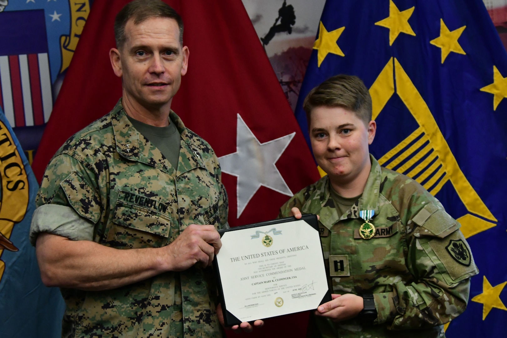 Maj. Gen. Reventlow, left, holding award certificate with Capt. Cloninger, right.