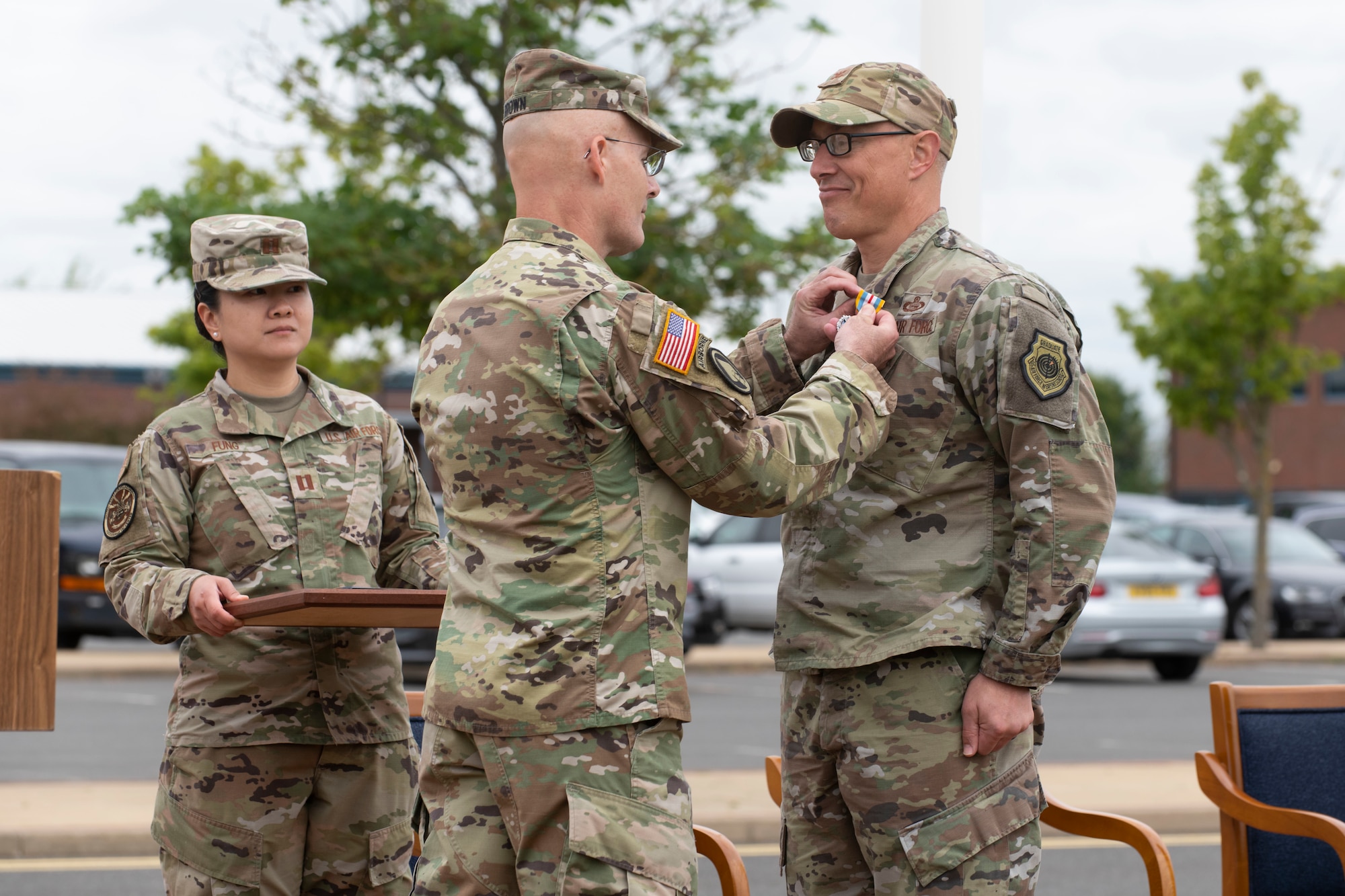 U.S. Air Force Col. Abraham Jackson, right, U.S. European Command Joint Intelligence Operations Center Europe Analytic Center outgoing commander, receives the Meritorious Service Medal during the JIOCEUR Analytic Center change of command ceremony at Royal Air Force Molesworth, England, July 7, 2022. The change of command ceremony is rooted in military history dating back to the 18th century representing the relinquishing of power from one officer to another. (U.S. Air Force photo by Senior Airman Jennifer Zima)