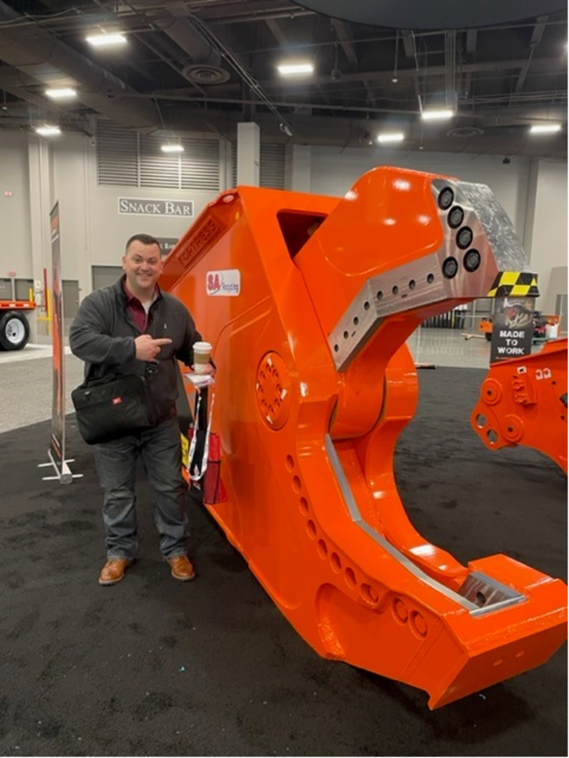 Man standing next to an orange piece of equipment
