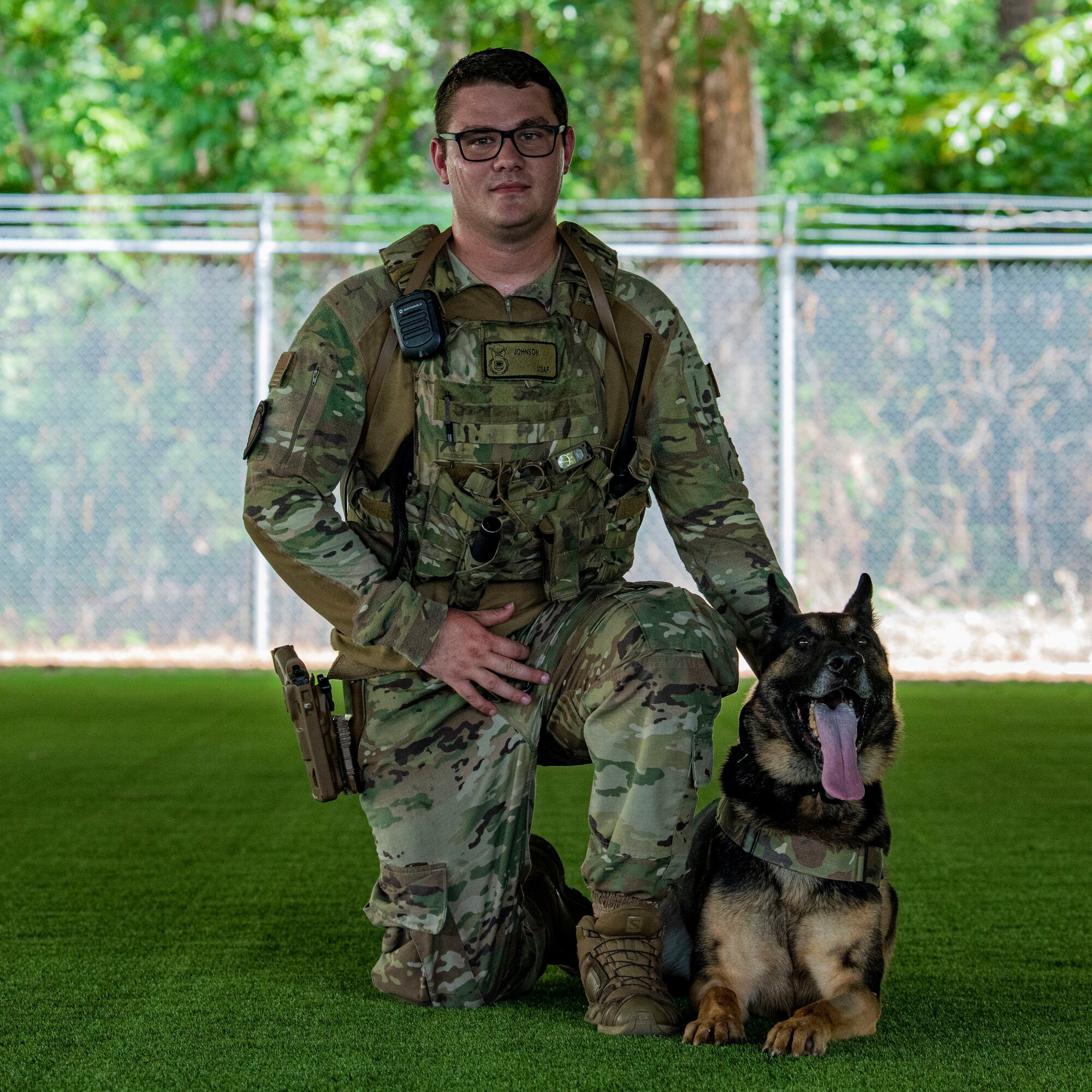 Staff Sgt. Kyle Johnson, 4th Security Forces Squadron military working dog handler, poses for a photo after conducting obedience training with MWD Donni at Seymour Johnson Air Force Base, North Carolina, July 6, 2022. The MWD handler’s mission is to act as a psychological deterrent for security forces Airmen, provide support for explosive detection and help detain subjects. (U.S. Air Force photo by Airman 1st Class Sabrina Fuller)