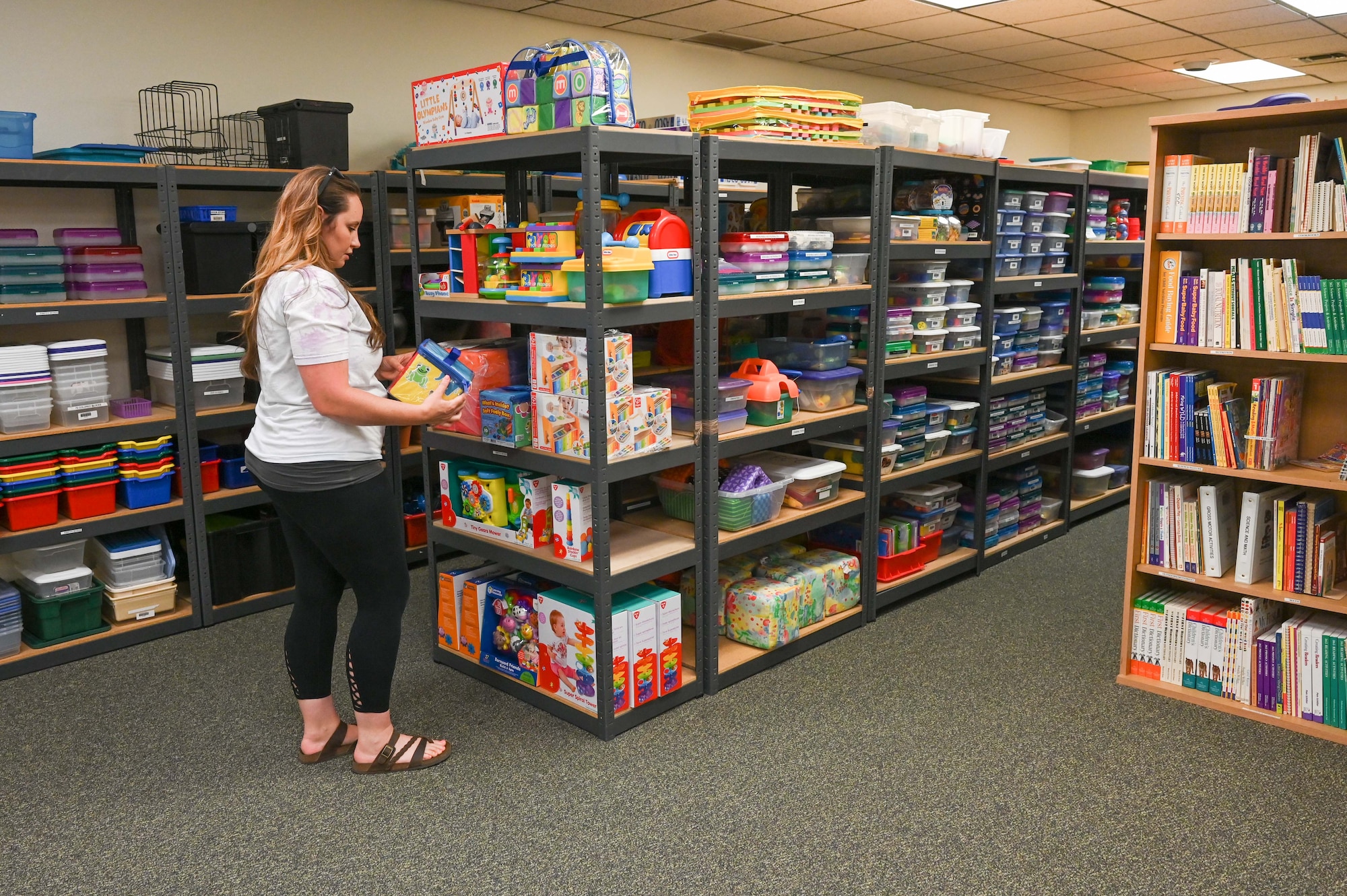 A family child care provider searches the lending library.
