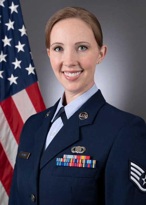 Headshot of SSgt Rachael Colman in front of the American flag. She is wearing the blue service dress uniform.