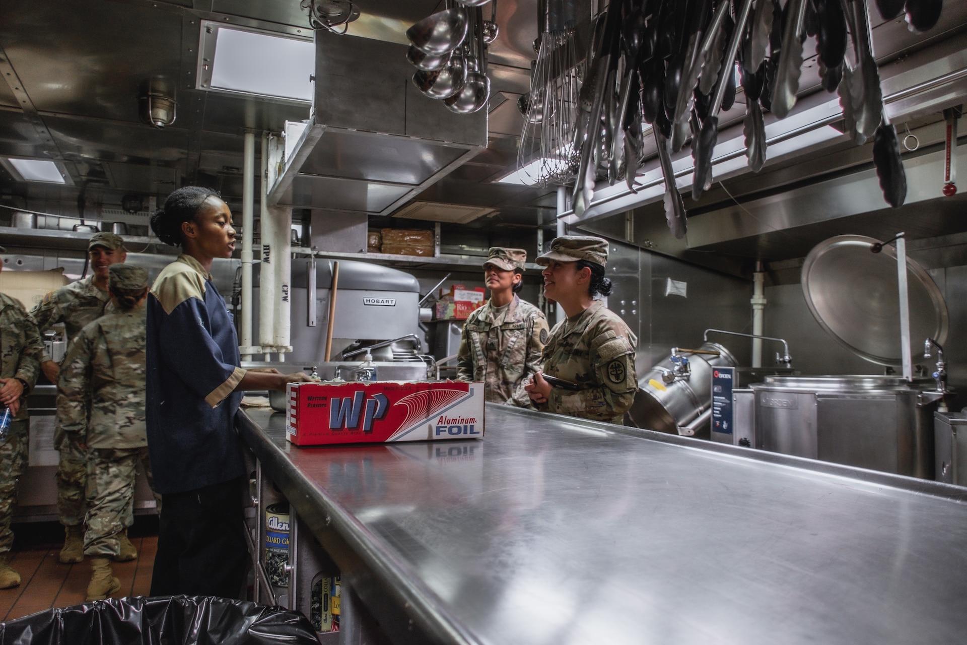 Col. Elba Villacorta and Sgt. Elizabeth Currie discuss RIMPAC food safety and preparation procedures with members of the U.S. Navy aboard the USS Hopper (DDG 70)