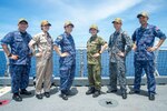 SOUTH CHINA SEA (June 18, 2022) – Service members from Japan Maritime Self-Defense Force (JMSDF), Japan Ground Self-Defense Force (JGSDF) and Japan Air Self-Defense Force (JASDF) embarked aboard Military Sealift Command hospital ship USNS Mercy (T-AH 19) in support of Pacific Partnership 2022 (PP22) pose for a photo on the ship's flight deck. Now in its 17th year, Pacific Partnership is the largest annual multinational humanitarian assistance and disaster relief preparedness mission conducted in the Indo-Pacific. (U.S. Navy Photo by Mass Communication Specialist 3rd Class Raphael McCorey)