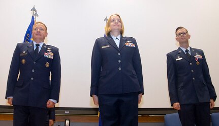 Three Air Force member pose on stage.