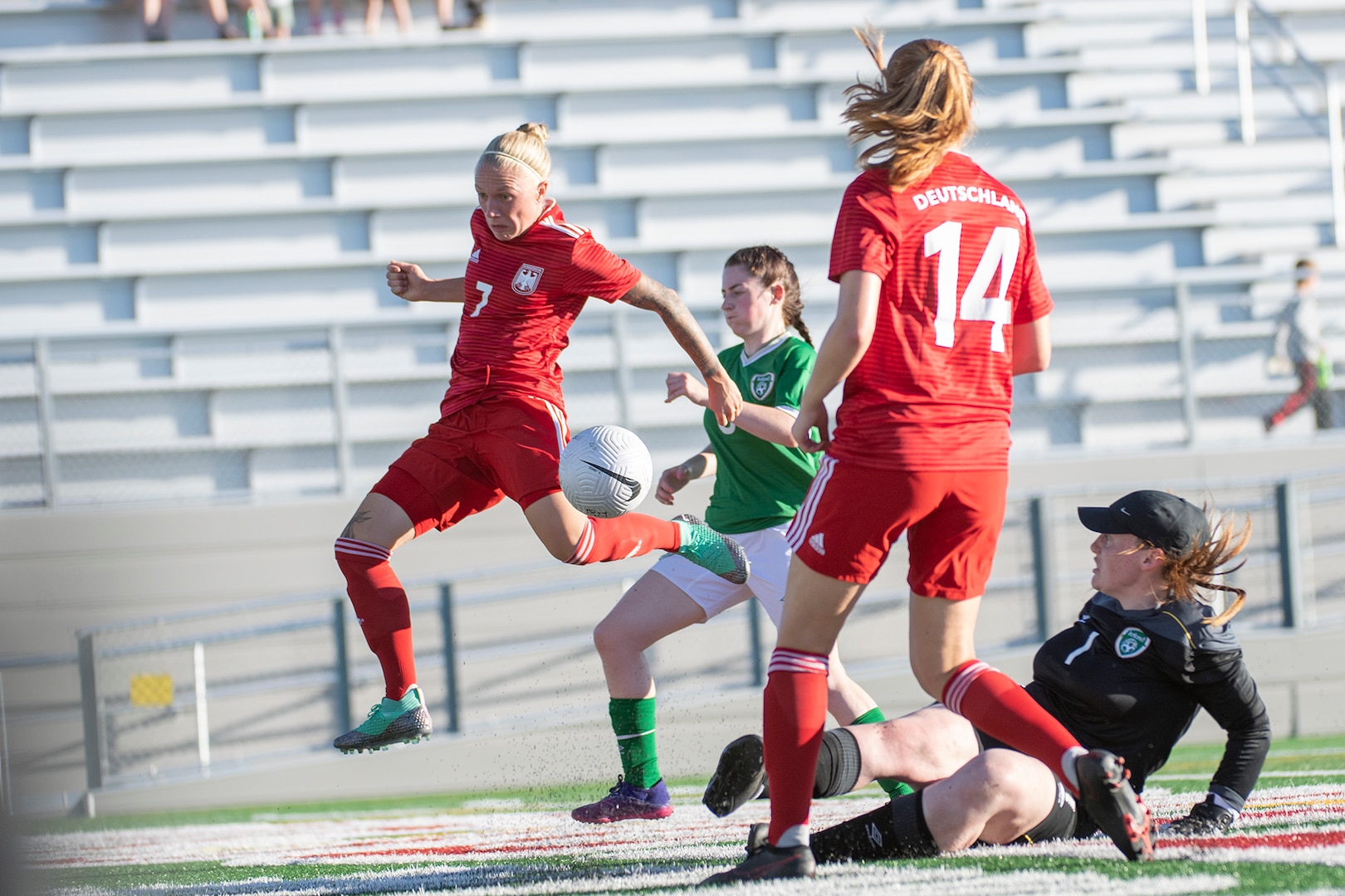 Germany’s 0R-3 Jil Ludwig, left, makes an assist for a goal by OR-4 Sonja Bartoshe, front, during the second round of opening night for the  13th CISM (International Military Sports Council) World Military Women’s Football Championship in Meade, Washington July 11, 2022.  Germany beat Ireland 3-0. (DoD photo by EJ Hersom)