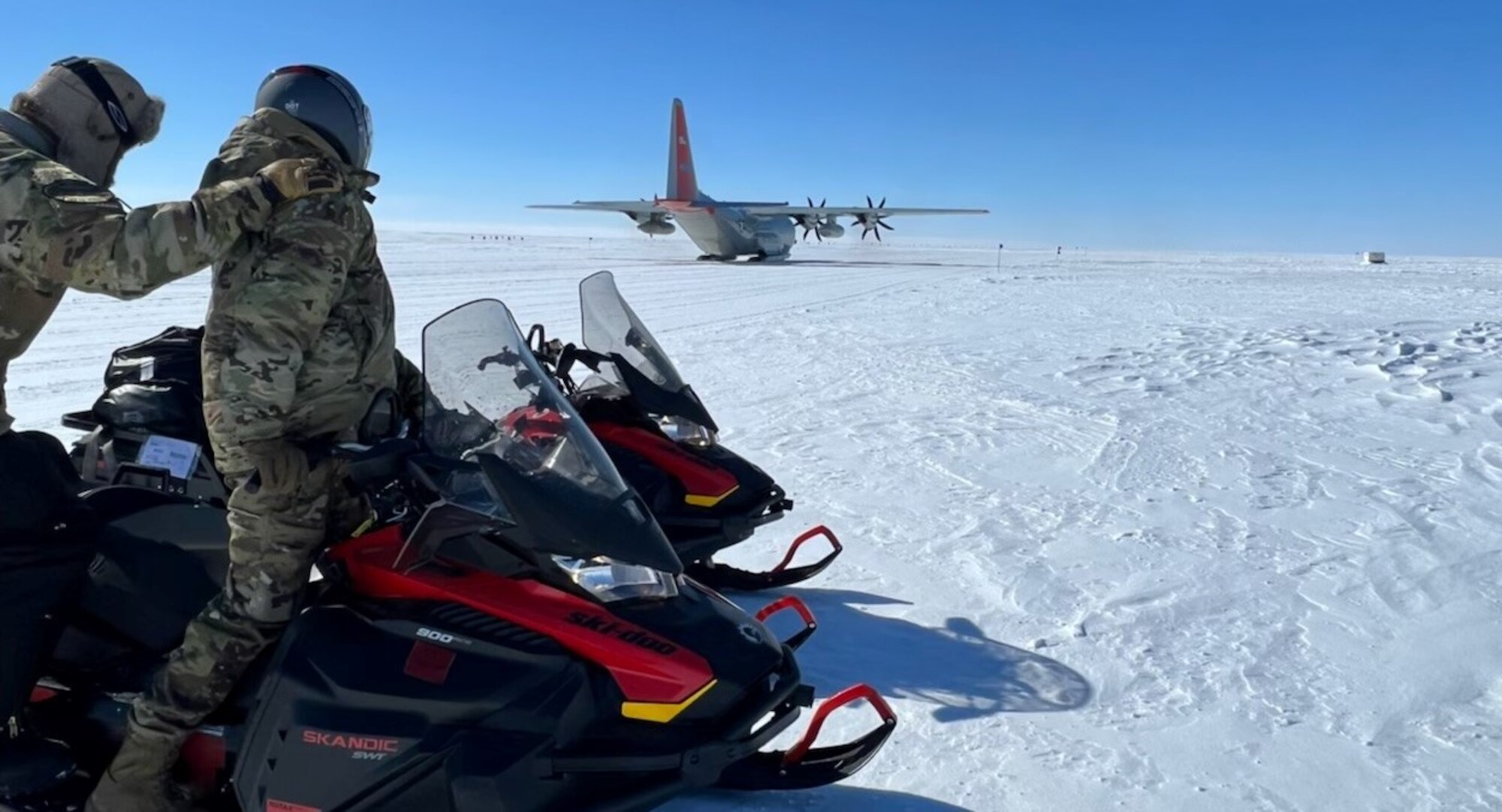 Three members of the 133rd Contingency Response Flight watch a LC-130 Hercules from the 109th Airlift Wing takes off in Kangerlussuaq, Greenland, May 14, 2022.