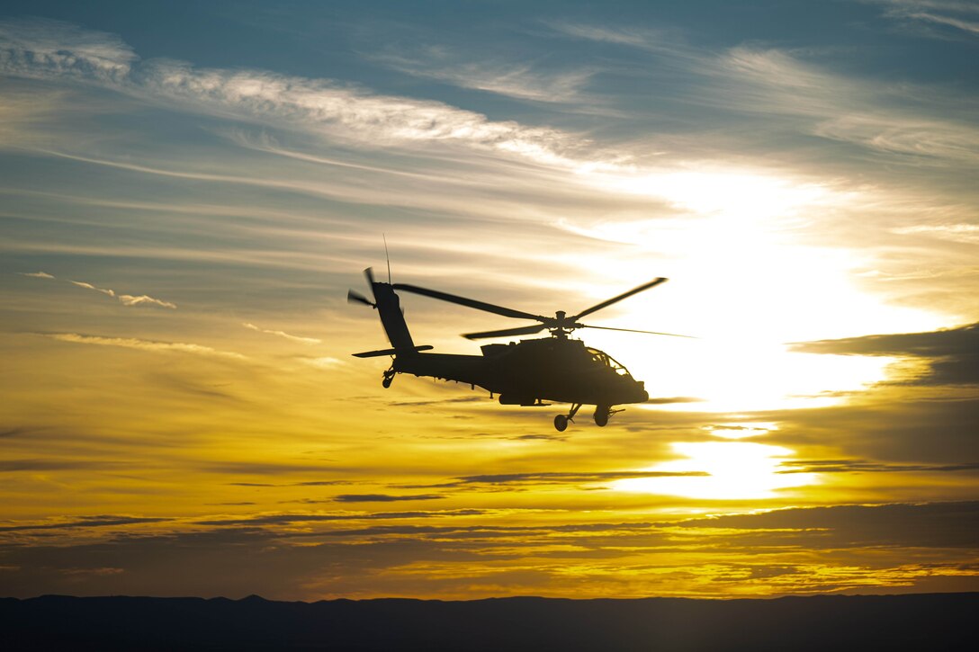 A helicopter flies at twilight.