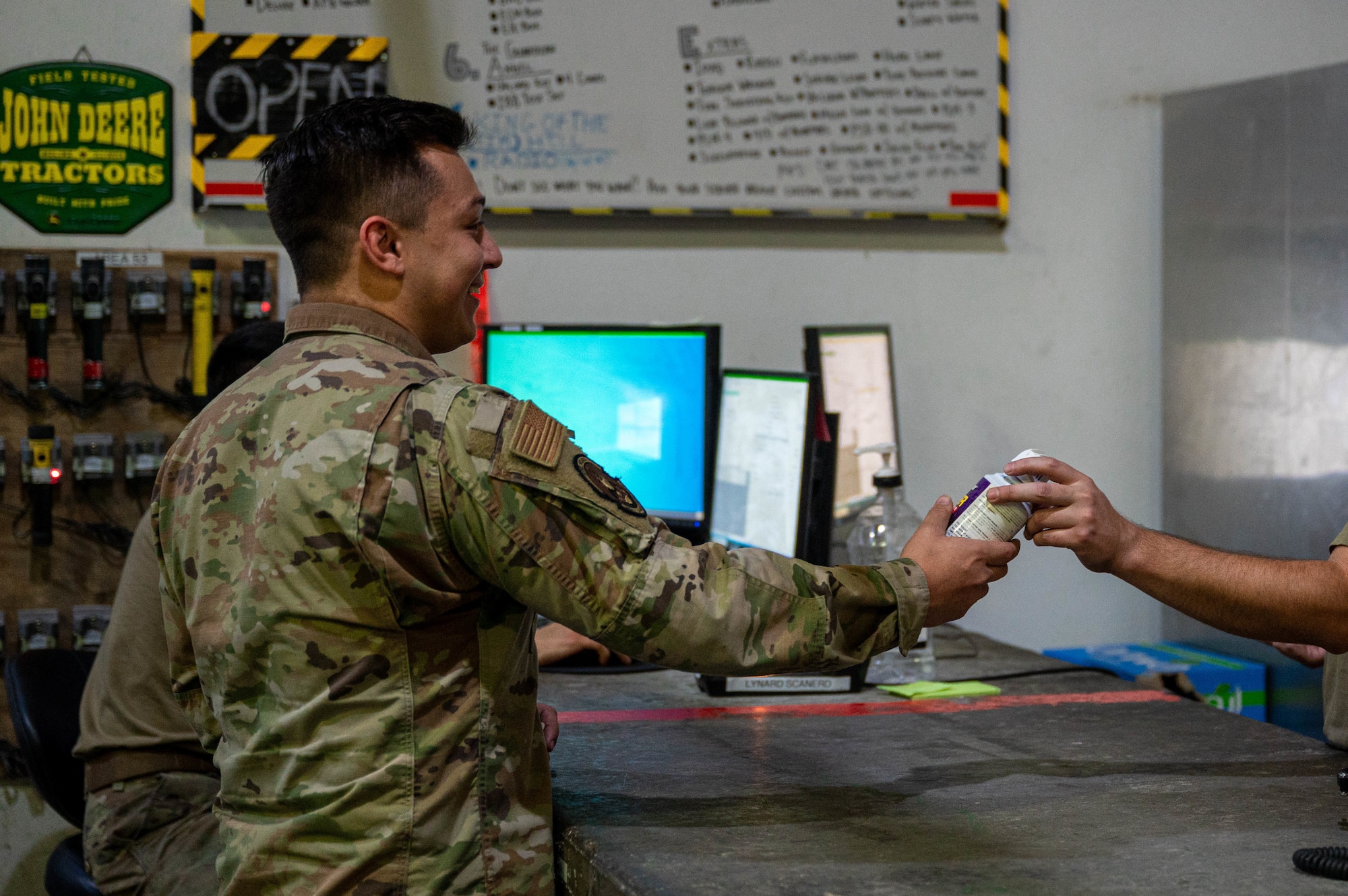 U.S. Air Force Staff Sgt. Justo Allen Boggs, a composite tool kit technician and fuel system mechanic with the 386th Expeditionary Aircraft Maintenance Squadron Sortie Support Component Equipment Maintenance Flight, hands over a checked out item to a service member at Ali Al Salem Air Base, June 23, 2022. Tools are often checked out of the shop by various specialty shops and coalition partners to perform maintenance on their aircraft. (U.S. Air Force photo by Senior Airman Natalie Filzen)