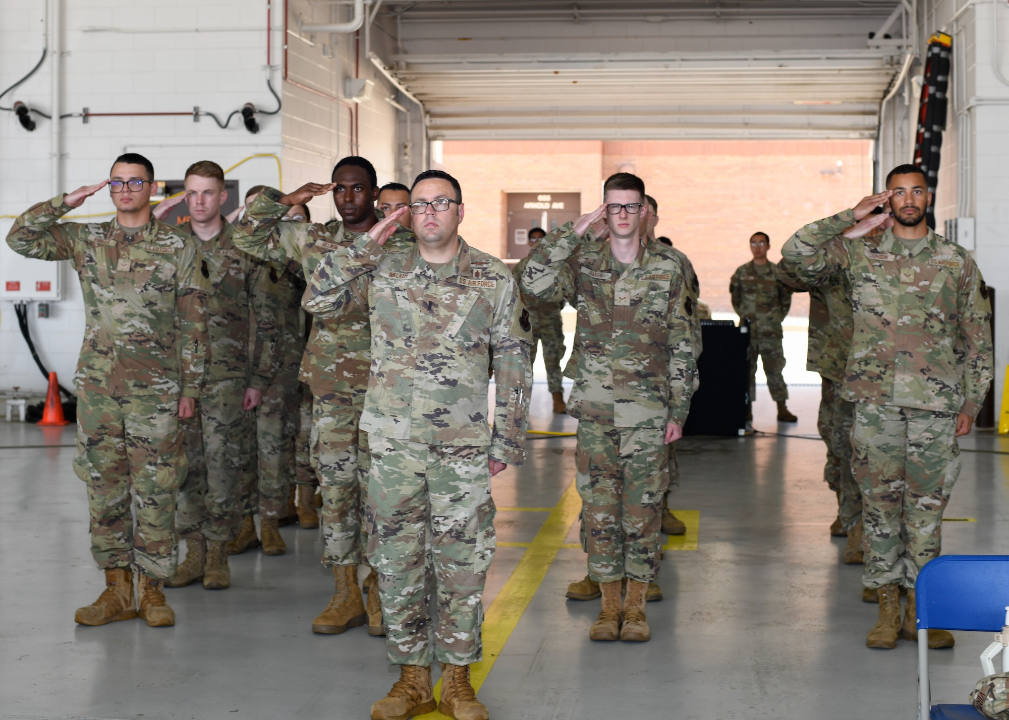 Airmen with the 509th Communications Squadron stand in formation and salute.