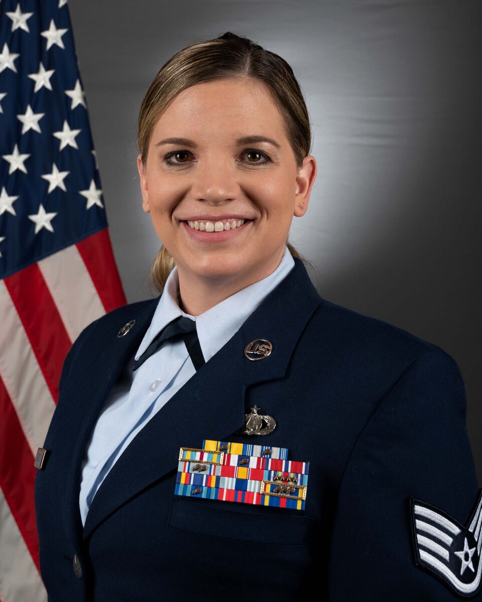 Official Headshot of SSgt Melissa Lackore in front of the American flag. she is wearing the blue service dress uniform.