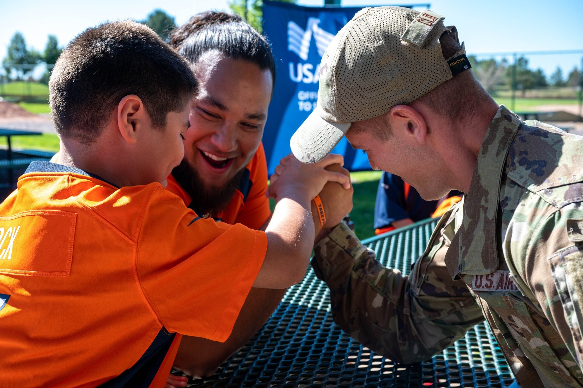 Mike Purcell, Denver Broncos defensive linebacker, engages in an arm wrestling match with Airman 1st Class Nathanael Clay, Space Base Delta 2 Commander Support Staff member, on Buckley Space Force Base, Colo., July 8, 2022. The Denver Broncos hosted a meet and greet for members of Team Buckley before receiving a tour of the base. (U.S. Space Force photo by Senior Airman Haley N. Blevins)