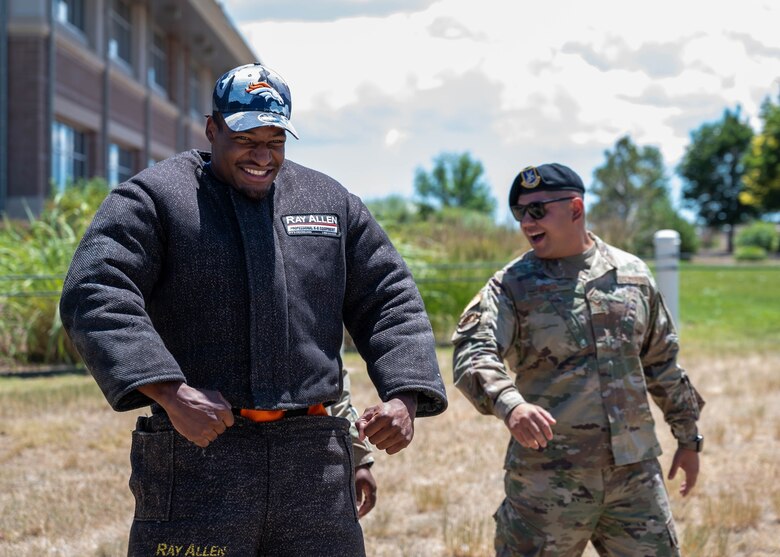 Jonas Griffith, Denver Broncos inside linebacker, flexes before participating in a military working dog demonstration on Buckley Space Force Base, Colo., July 8, 2022. The MWD demonstration was part of the tour the Broncos received while visiting Buckley. (U.S. Space Force photo by Senior Airman Haley N. Blevins)