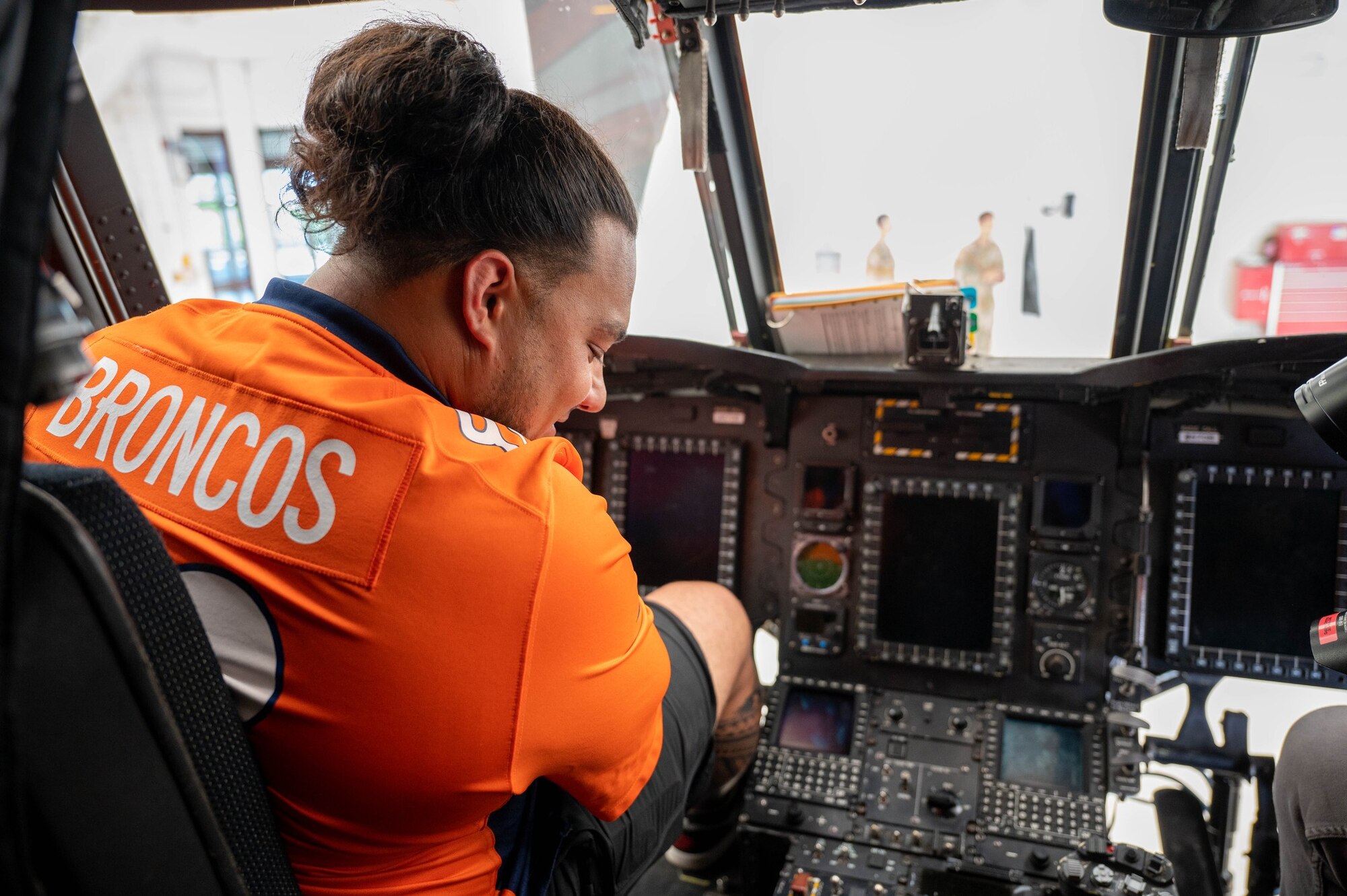 Mike Purcell, Denver Broncos defensive linebacker, sits in a CH-47 Chinook helicopter at Army Aviation on Buckley Space Force Base, Colo., July 8, 2022. Members from the Denver Broncos learned about various aircraft while visiting Army Aviation. (U.S. Space Force photo by Senior Airman Haley N. Blevins)