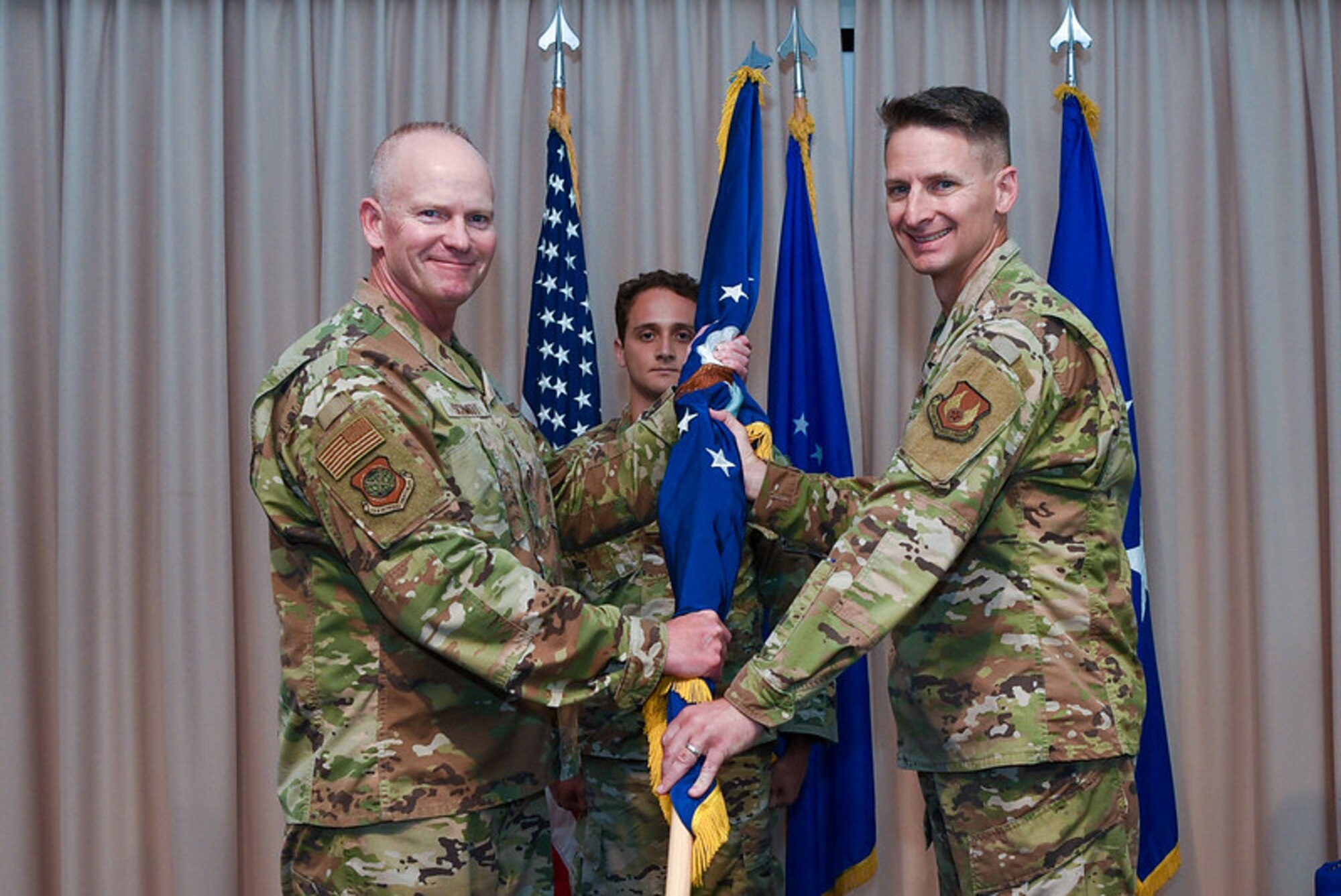 Col. Christopher Ward, senior materiel leader, Aerial Networks Division, accepts division leadership from then-Maj. Gen. Michael Schmidt, program executive officer, Command, Control, Communications, Intelligence and Networks, during a change of leadership ceremony at Hanscom Air Force Base, Mass., June 23. The following week, Schmidt was promoted to lieutenant general and assumed leadership of the Joint Strike Fighter Program, Office of the Secretary of Defense, headquartered in Arlington, Virginia, July 5. (U.S. Air Force photo by Mark Herlihy)