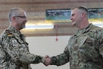 U.S. Army Capt. Zachary Thompson (right) commander, Headquarters-Headquarters Company, 193rd Military Police Battalion, Colorado Army National Guard, and Lt. Col. Christian Goessiger, military police officer, German Army Reserves, shake hands as part of a U.S. and German Reserve Officer Exchange Program, June 4, 2022, at the Denver Armory, Denver, Colorado. The officer exchange program, which was created to exchange officers between nations in order to collaborate on leadership and to create and strengthen alliances with our allied nations for further support in future conflicts, mirrors the National Guard Bureau State Partnership Program. (U.S. Army National Guard photo by Spc. Clayton Eggan)