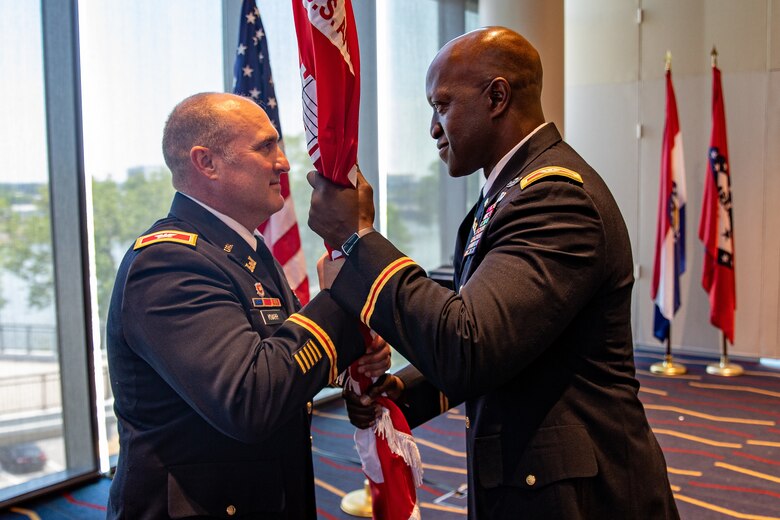 two men passing a flag