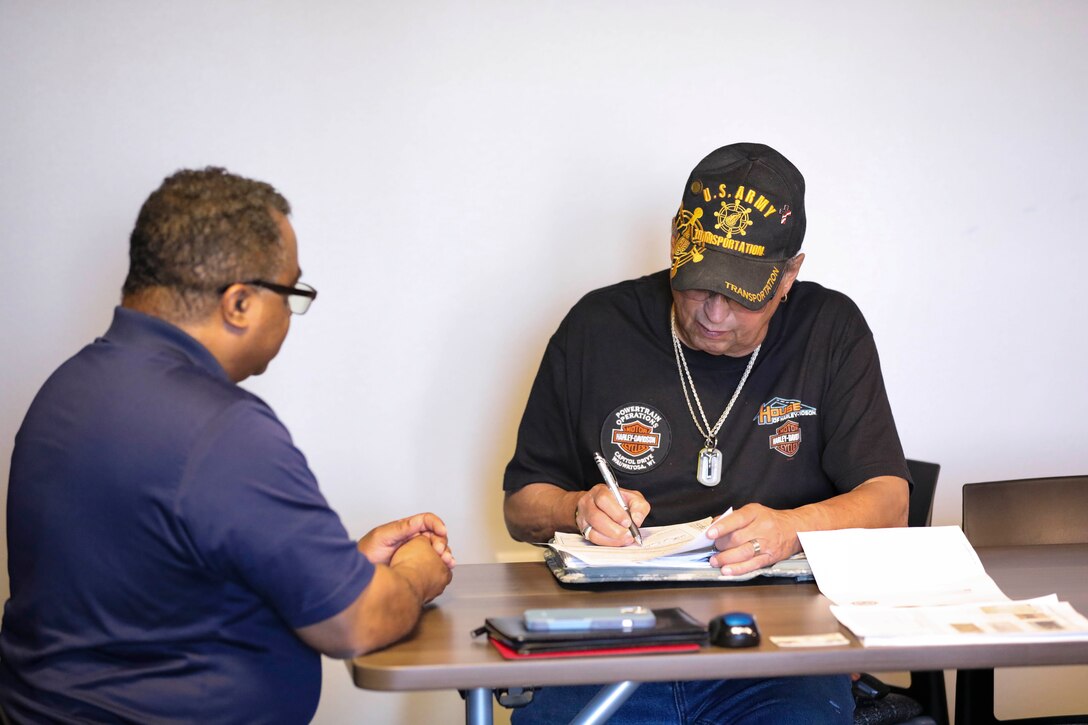 Forrest Powell, left, deputy director, state of Alaska Office of Veterans Affairs, assists local veterans with their earned benefits during an outreach event at the Aurora Inn in Nome, Alaska, July 9, 2022. During the two-day event in Nome 22 veterans filed claims for benefits that they earned through military service. (Alaska National Guard photo by 1st Lt. Balinda O’Neal)