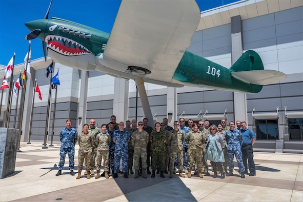 Members of the Space Tacticians Course stand in front underneath a static display of a P-40 Warhawk aircraft after completion of their course at Vandenberg Space Force Base, California, June 30, 2020. Hosted by Space Delta 5’s 55th Combat Training Squadron, the 8-day course consisted of 39 total personnel, 19 students and 20 instructors, from Australia, Canada, New Zealand, U.K. and U.S. with the intent of enhancing current global space operations through effective planning. (U.S. Space Force photo by Tech. Sgt. Luke Kitterman)