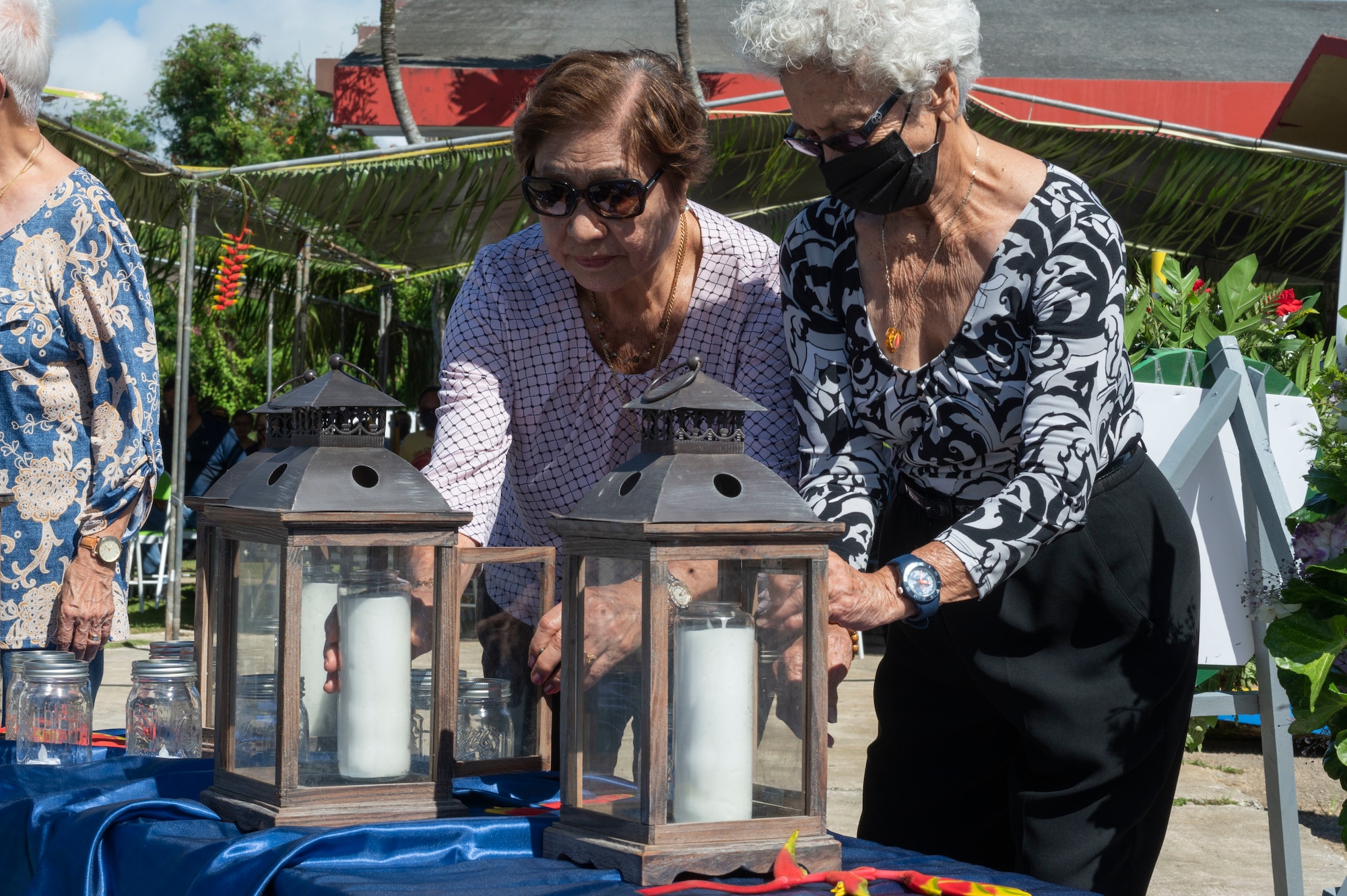 Two women putting candles in lanterns.