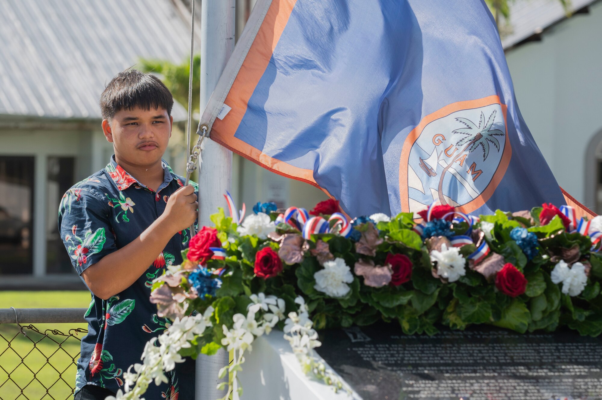 A boy raising the Guam flag.