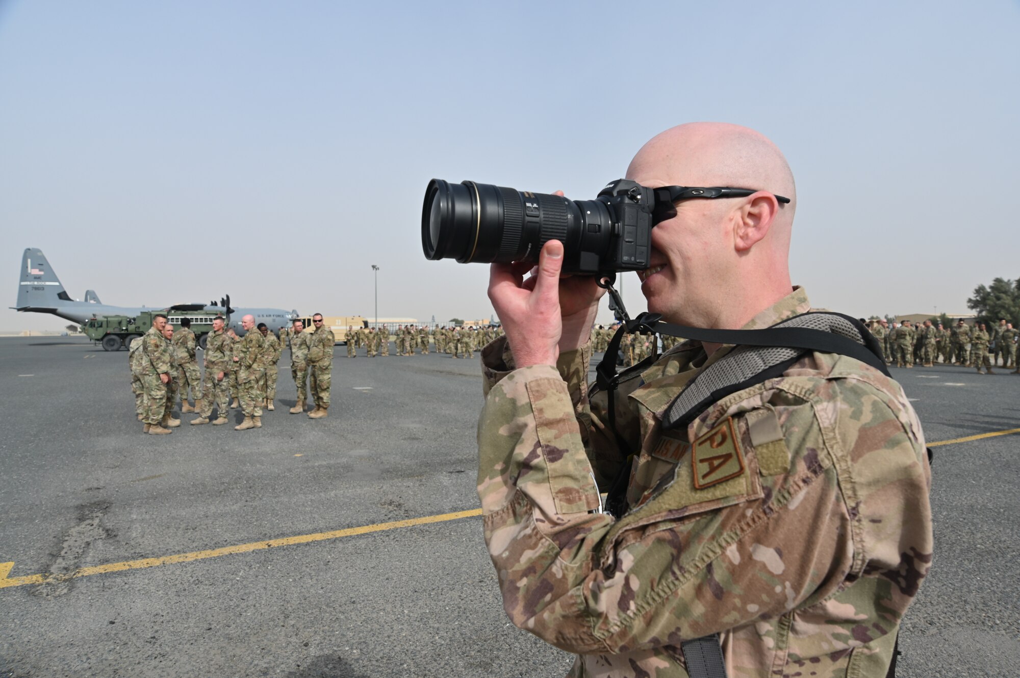 U.S. Air Force Tech. Sgt. Patrick Evenson takes photos of various groups under the 386th Air Expeditionary Wing at Ali Al Salem Air Base Kuwait, March 3, 2022. The official group photos served as a historical artifact of the members who deployed to the 386th AEW. (U.S. Air Force photo by Master Sgt. Arthur Wright)