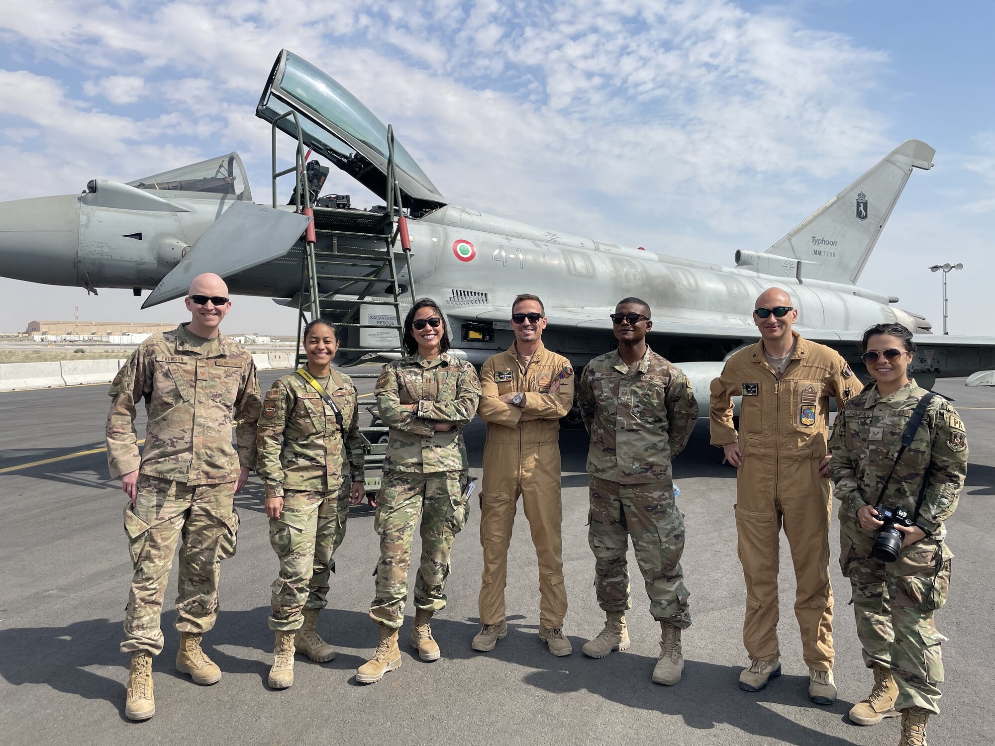 From left, U.S. Air Force Tech Sgt. Patrick Evenson, Senior Airman Daira Jackson, Capt. Melissa Heintz, Italian Air Force Maj. Davide Rovereto, Master Sgt. Arthur Wright, Italian Air Force Lt. Col. Claudio Surace and Airman 1st Class Natalie Filzen pose for a photo in front of an Italian Air Force Eurofighter Typhoon at Ali Al Salem Air Base, Kuwait, Feb. 21, 2022. The Air Force public affairs team  collaborated with coalition partners on photo shoots and events throughout their deployment. (U.S. Air Force courtesy photo)
