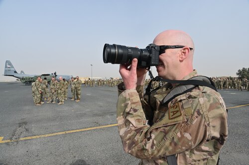 U.S. Air Force Tech. Sgt. Patrick Evenson takes photos of various groups under the 386th Air Expeditionary Wing at Ali Al Salem Air Base Kuwait, March 3, 2022. The official group photos served as a historical artifact of the members who deployed to the 386th AEW. (U.S. Air Force photo by Master Sgt. Arthur Wright)