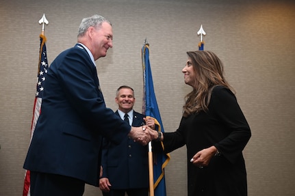 Col. Terry McClain, 433rd Airlift Wing commander, and Bianca Rhodes, Knight Aerospace president and CEO, shake hands during the 433rd AW Honorary Commanders’ Induction Ceremony in San Antonio, July 9, 2022. The ceremony included each honorary commander receiving an Air Force commander’s insignia pin and assuming honorary command by accepting the 433rd AW guidon. (U.S. Air Force photo by Senior Airman Brittany Wich)