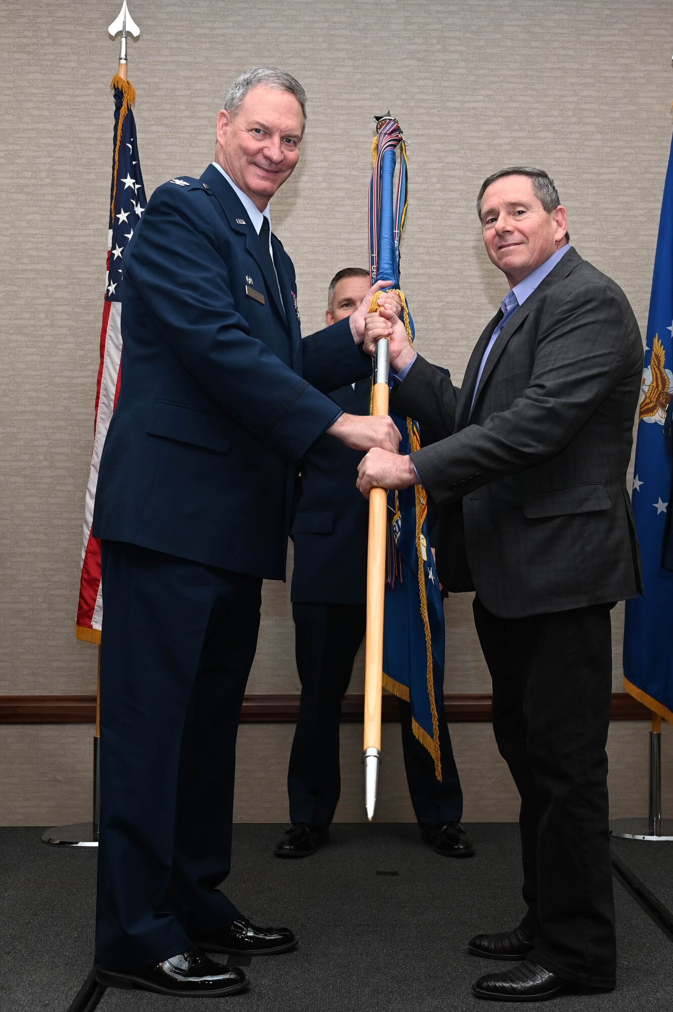 Col. Terry McClain, 433rd Airlift Wing commander, hands the 433rd AW guidon to Lee Randolph, managing partner of UBuildIt-Schertz, Texas, during the Honorary Commanders’ Induction Ceremony in San Antonio, July 9, 2022. Honorary commanders have opportunities to learn about their units and commanders through C-5M Super Galaxy tours, demonstrations, events and flights. (U.S. Air Force photo by Senior Airman Brittany Wich)