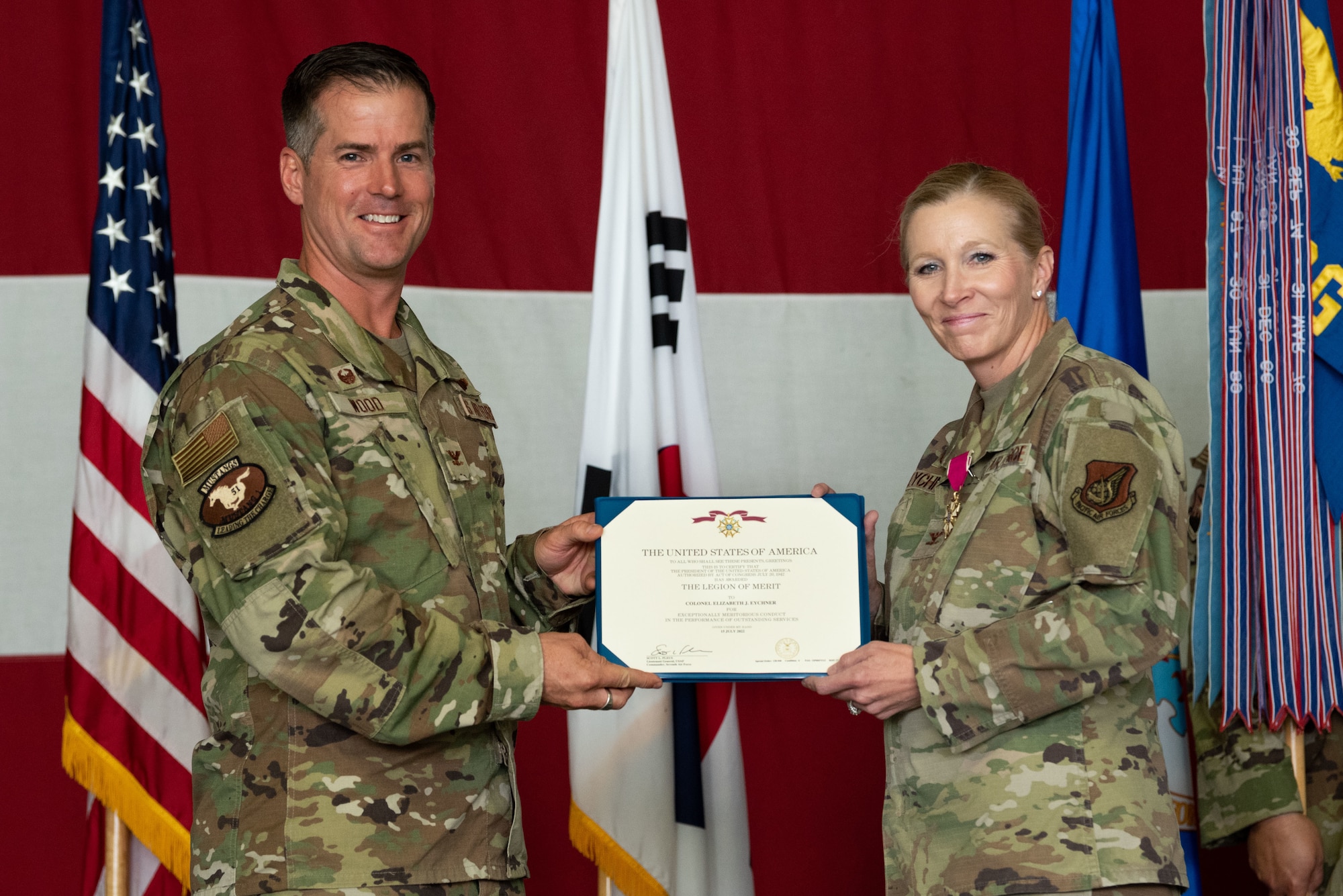 Col. Joshua Wood, 51st Fighter Wing commander, presents Col. Jonelle Eychner, 51st Mission Support Group outgoing commander, with the Legion of Merit medal during the 51st MSG change of command ceremony at Osan Air Base, Republic of Korea, July 13, 2022.