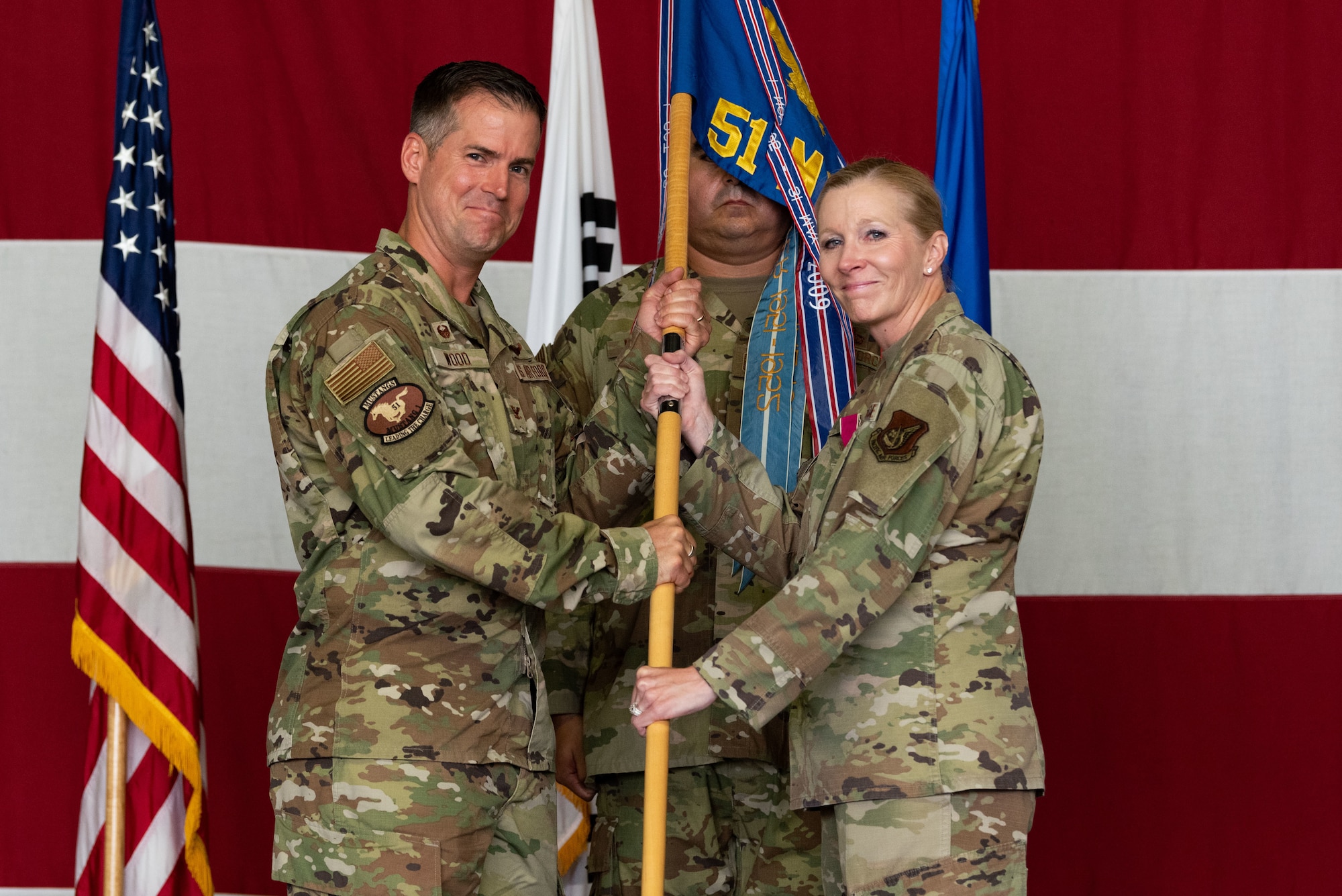 Col. Joshua Wood, 51st Fighter Wing commander, receives the guidon from Col. Jonelle Eychner, 51st Mission Support Group outgoing commander, during the 51st MSG change of command ceremony at Osan Air Base, Republic of Korea, July 13, 2022.