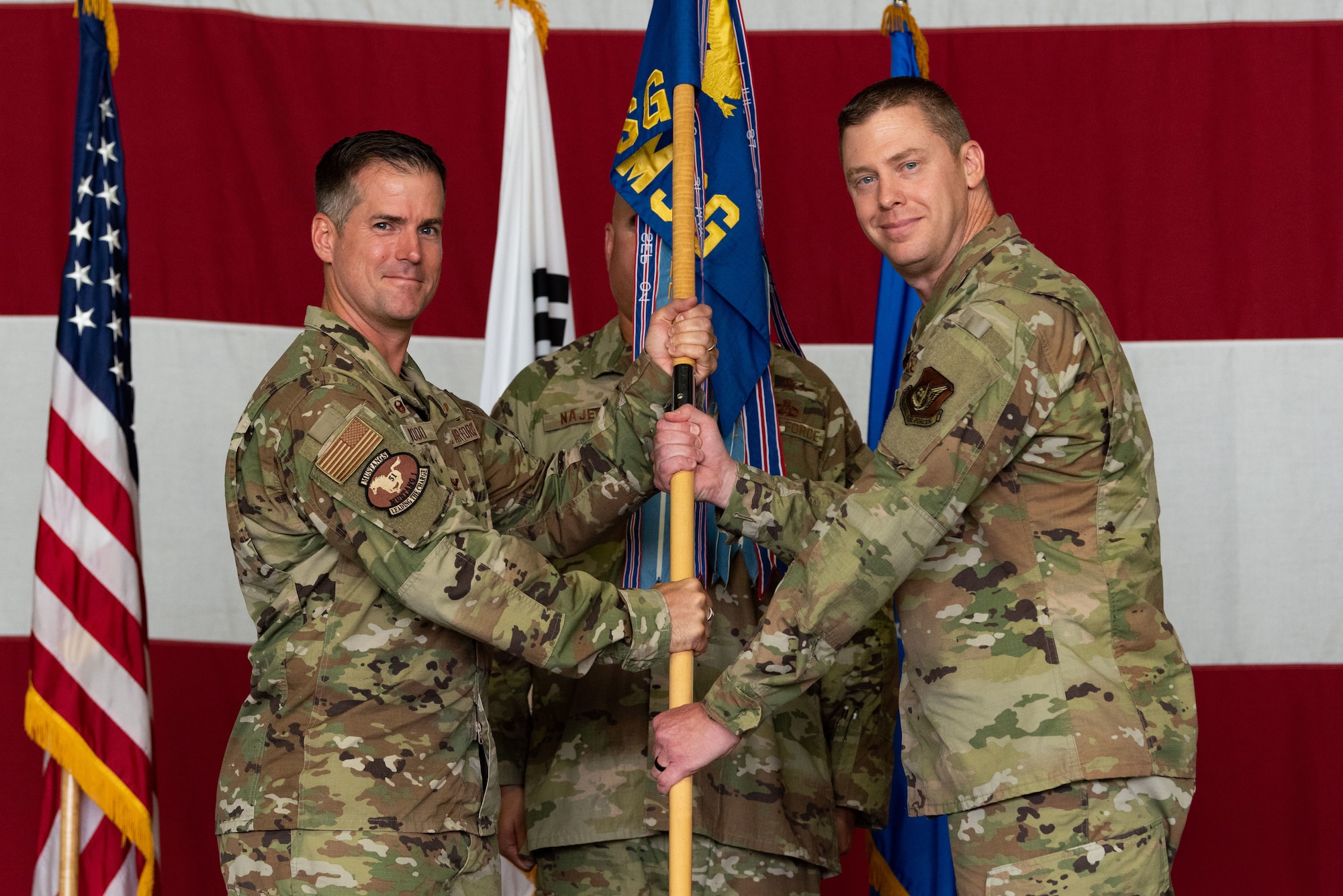 Col. Joshua Wood, 51st Fighter Wing commander, passes the guidon to Col. Kyle Grygo, 51st Mission Support Group incoming commander, during the 51st MSG change of command ceremony at Osan Air Base, Republic of Korea, July 13, 2022.