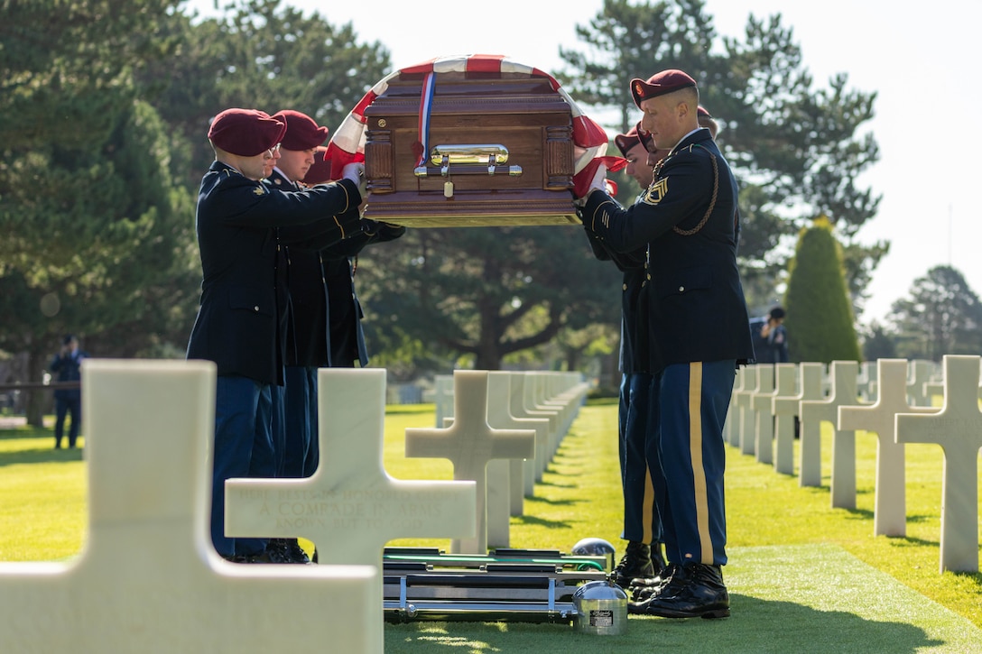Soldiers lower a casket into the ground.