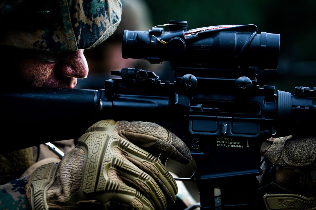 A Marine looks through the scope of a weapon.