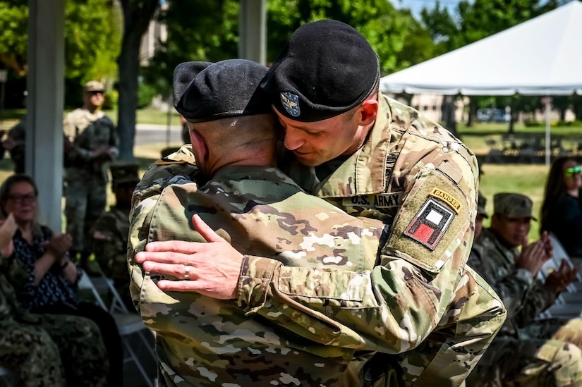 U.S. Army Col. James Krueger, 174th Infantry Brigade incoming commander, embraces U.S. Army Col. Mathew Bunch, 174th Infantry Brigade commander during a change of command ceremony on 13 July, 2022 at Joint Base McGuire-Dix-Lakehurst N.J. The 174th Infantry Brigade is responsible for preparing soldiers of the U.S. Army Reserve and National Guard for deployment through battle training in maneuvers, equipment, and other details. (U.S. Air Force photo by Senior Airman Matt Porter)