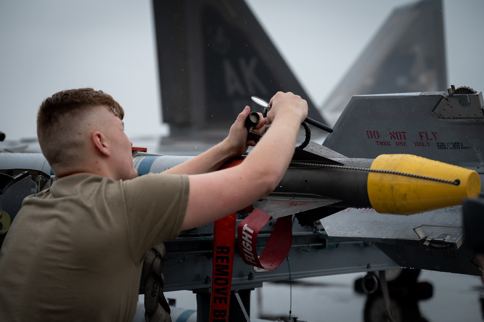 A photo of a U.S. Airman unloading a Captive Air Training Missile from its stand