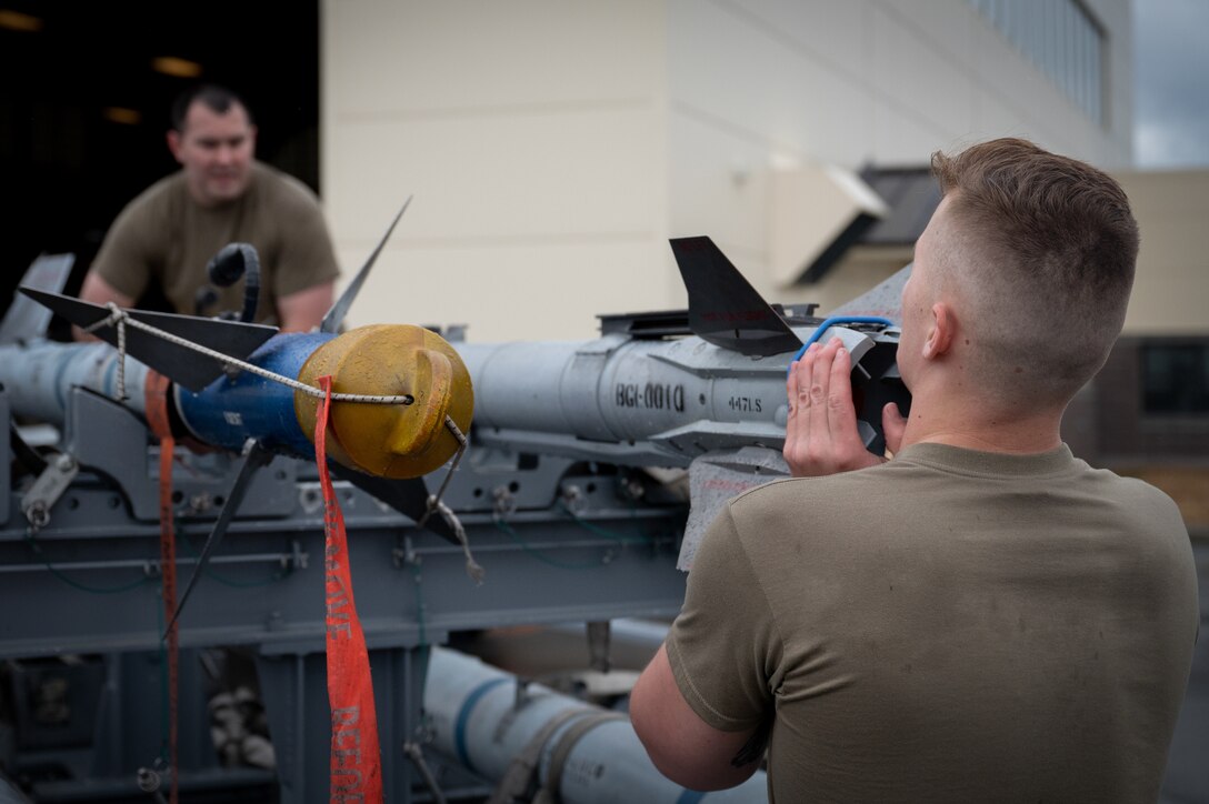 A photo of two U.S. Airmen lifting a Captive Air Training Missile