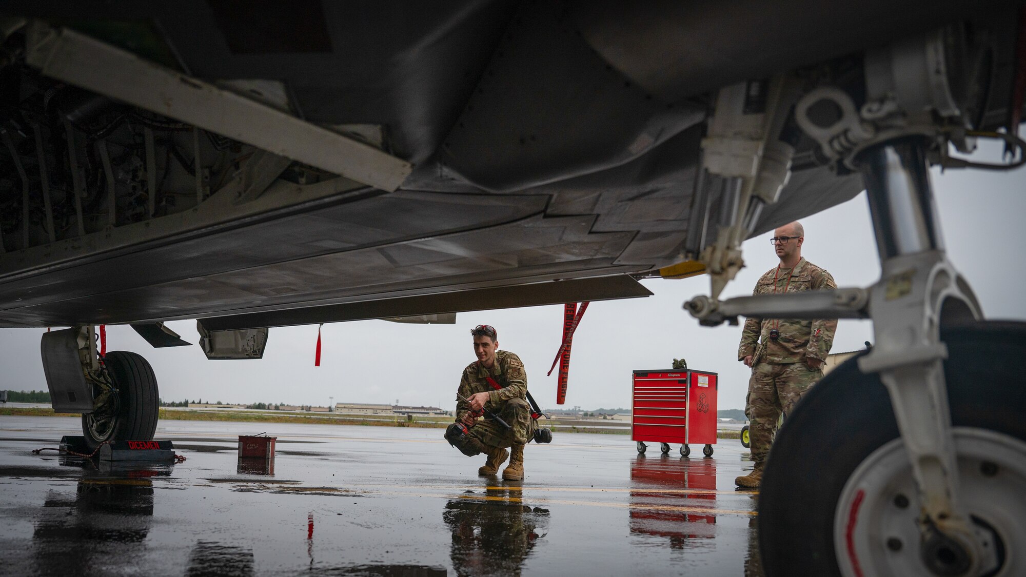 A photo of a U.S. Airman preparing an F-22 Raptor for a missile load