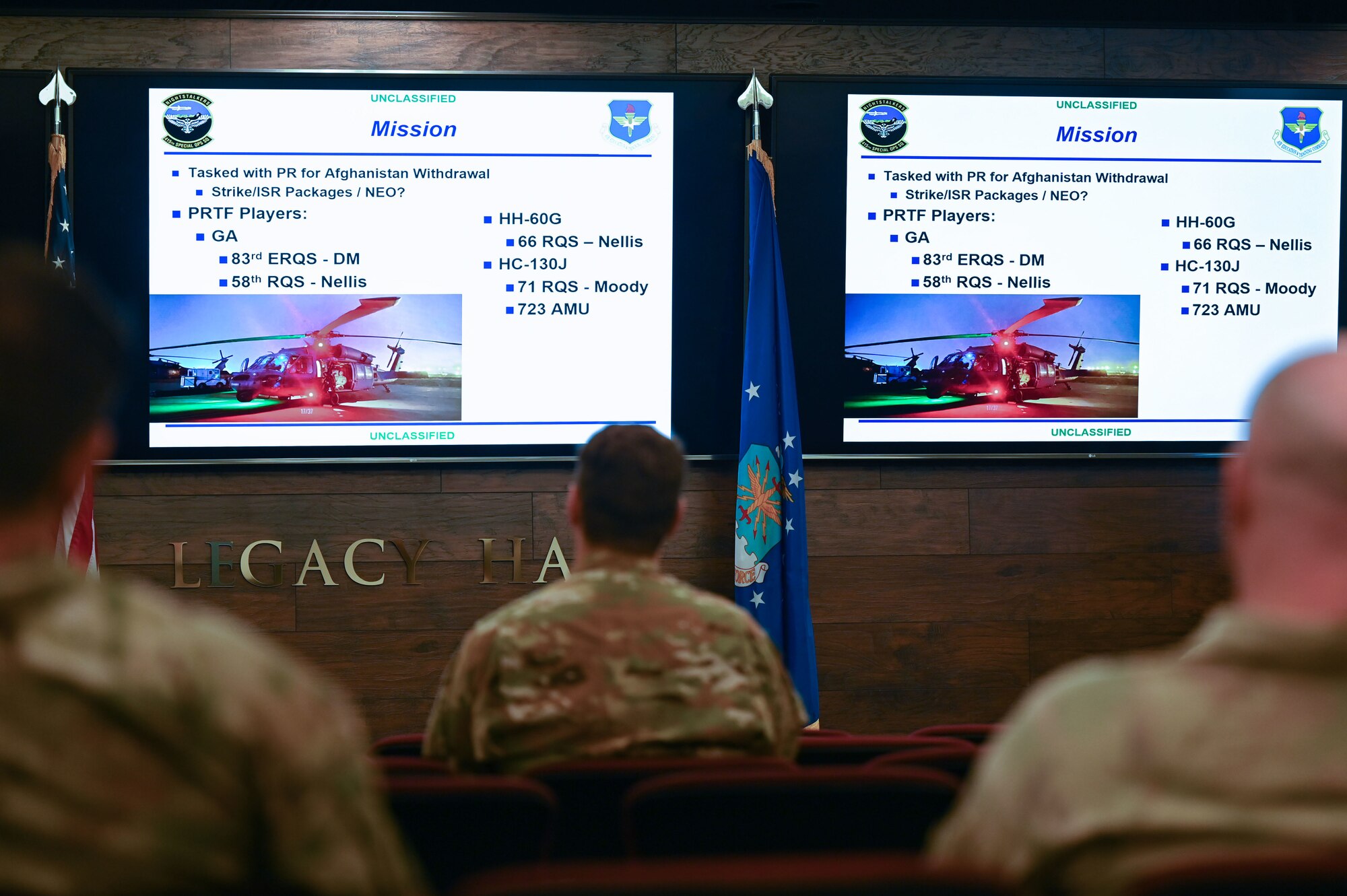 A group of people listen to a briefing.