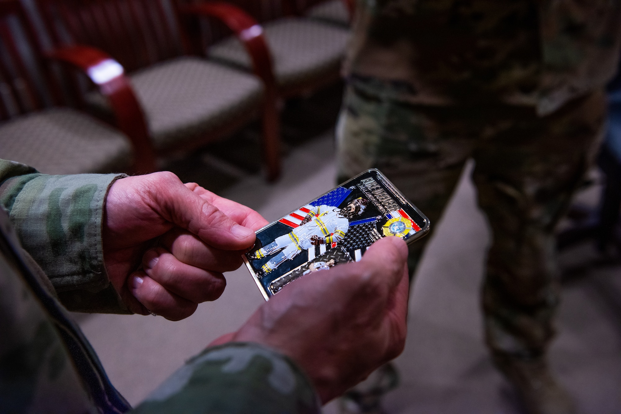 Chief Master Sergeant of the Space Force Roger A. Towberman inspects a coin he received from the 312th Training Squadron , at Goodfellow Air Force Base, Texas, July 8, 2022. The 312th TRS trains all Department of Defense and allied forces fire protection professionals. (U.S. Air Force photo by Senior Airman Michael Bowman)