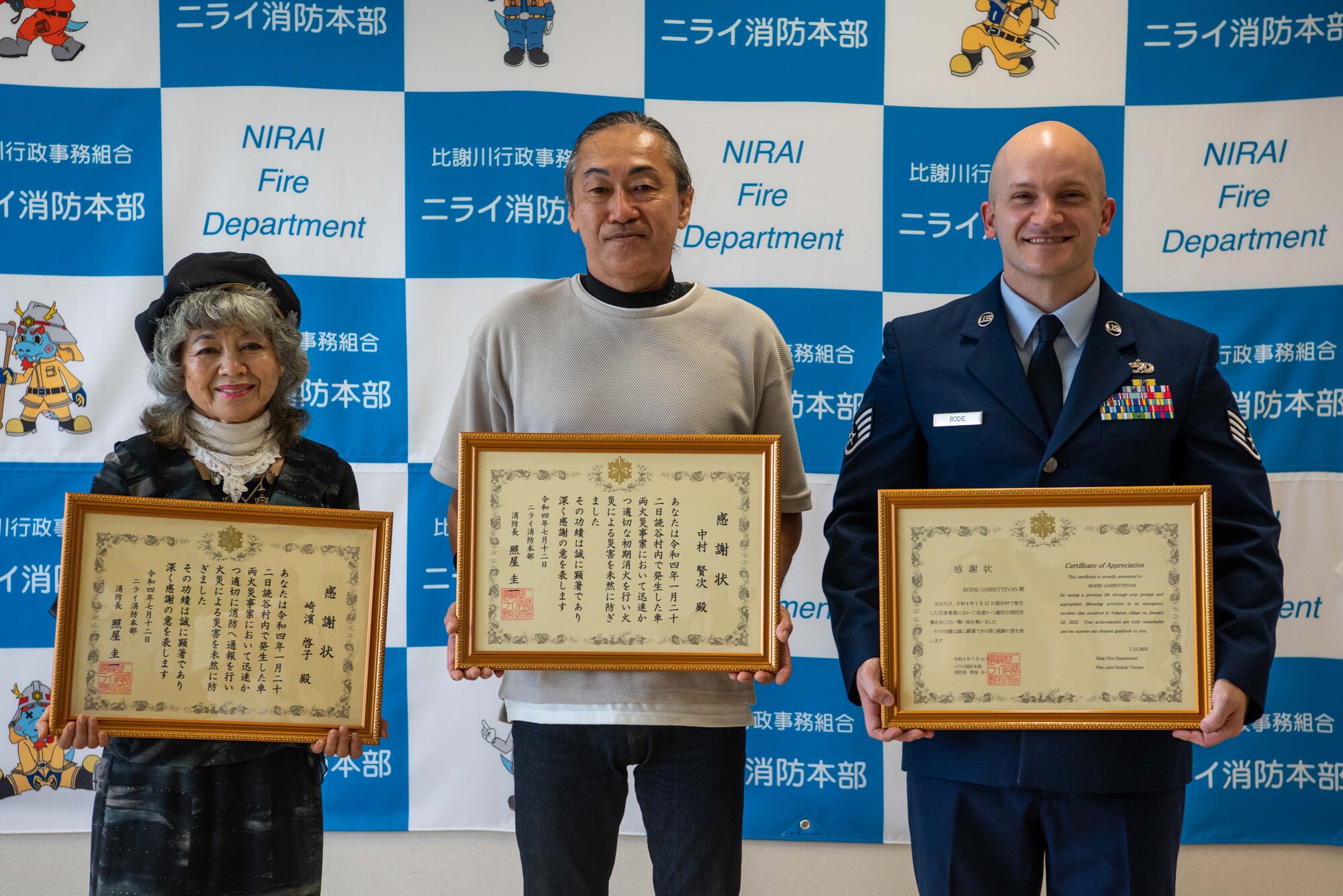 An Airman poses for a photo alongside two other people.