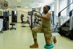 U.S. Air Force Staff Sgt. Lashawn Dennis, 52nd Fighter Wing non-commissioned officer in charge of the wing professional development office, performs a physical therapy exercise in the medical clinic at Spangdahlem Air Base, Germany, June 14, 2022. Physical therapy allows Airmen to work through their injuries and provides tools for prevention in the future. (U.S. Air Force photo by Staff Sgt. Chance Nardone)