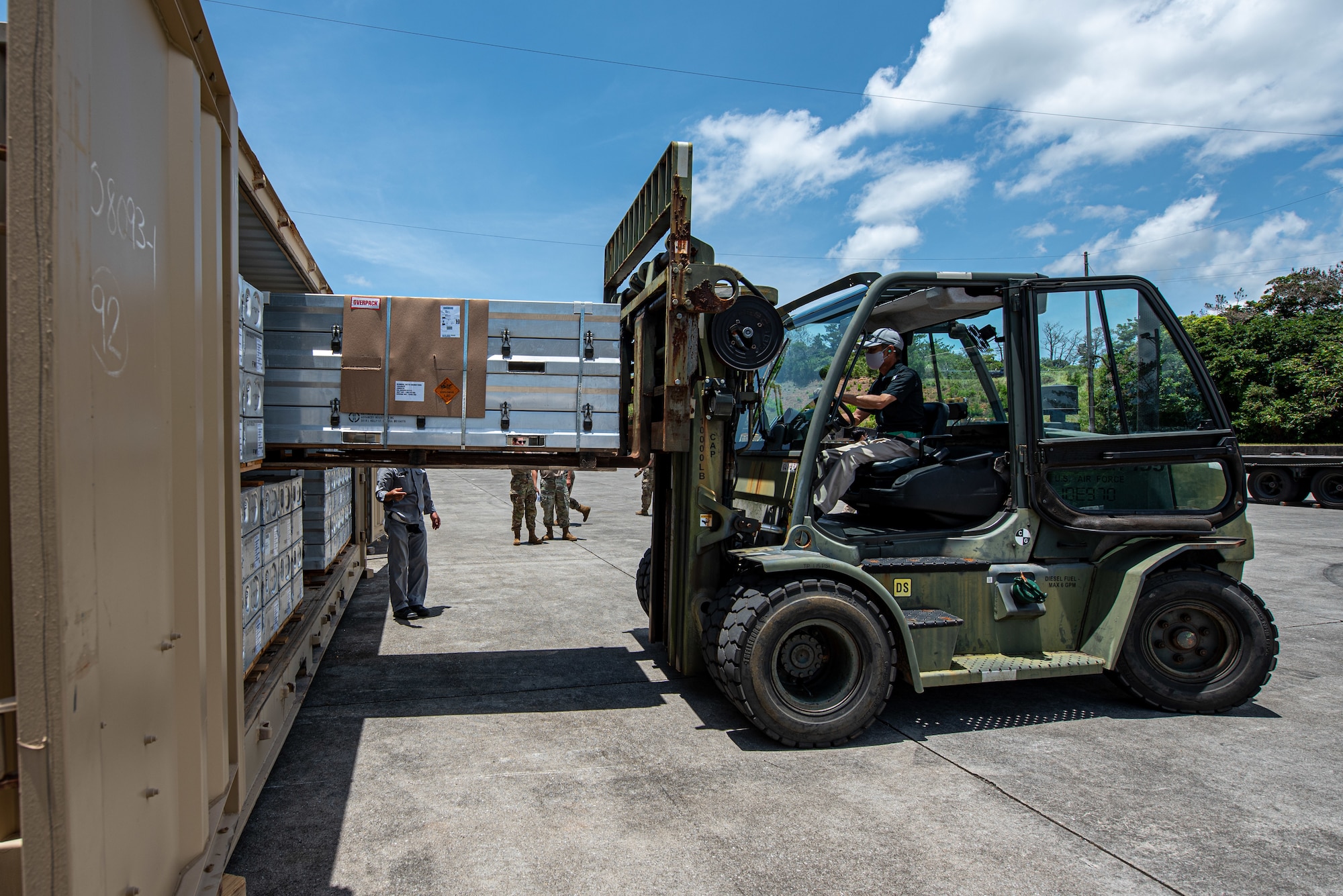 A forklift operator lifts munitions.