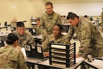 Pvt. Thomas Glover, a financial management technician with Detachment B, 9th Financial Management Support Unit, Special Troops Battalion, 1st Infantry Division Sustainment Brigade, helps a customer during the unit’s certification exercise June 18 at Fort Riley, Kansas. The exercise simulated a deployed environment that gave Glover and his fellow Soldiers an example of what it is like overseas. (Sgt. Walter Carroll, 1st Inf. Div. Sust. Bde. Public Affairs)