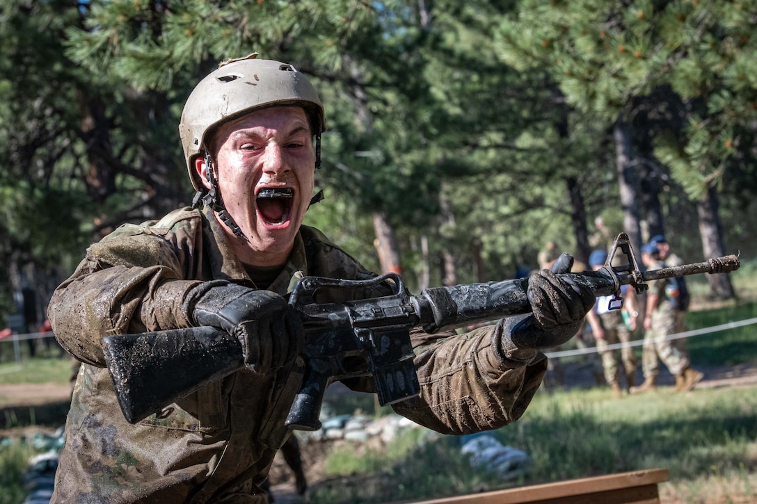 A cadet shouts while running with a training rifle.