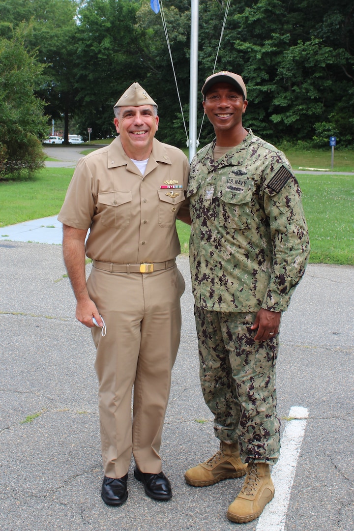 Rear Adm. Matthew Case and Capt. David Thomas outside by the flag pole at Naval Health Clinic Patuxent River.